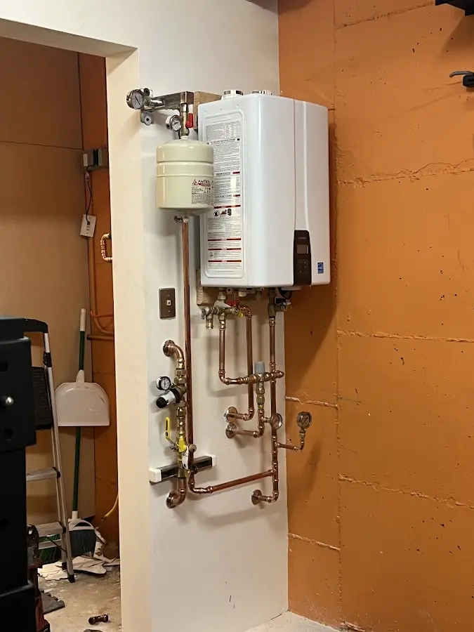 Plumbing technician inspecting water heater connections in West Clarkston-Highland
